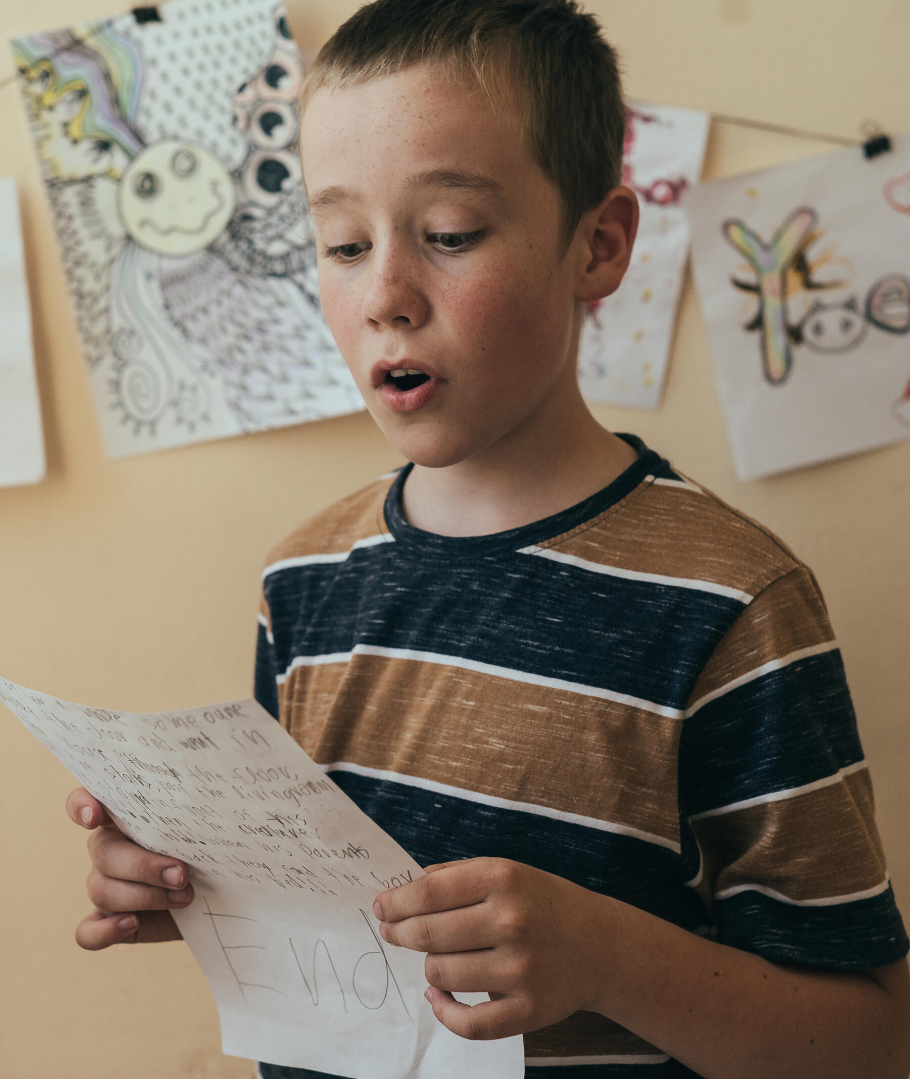 young student reading his original work for the audience